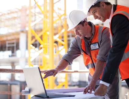 Engineers reviewing MEP drawings on a construction site